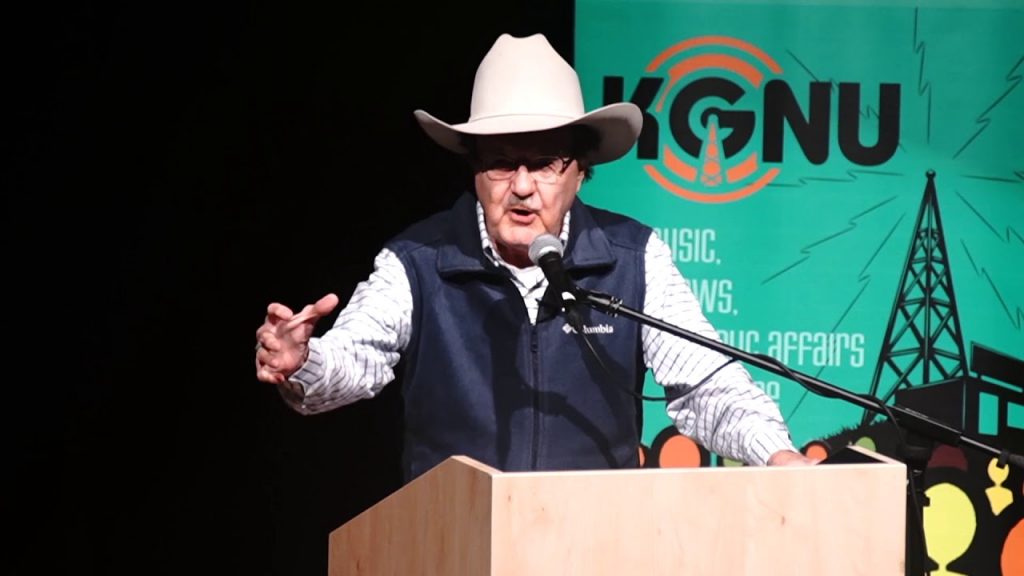 A man in a cowboy hat giving a speech at a podium