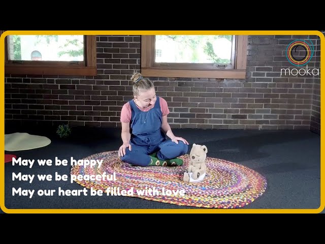 a little girl sitting on a rug playing with a dog and smiling brightly