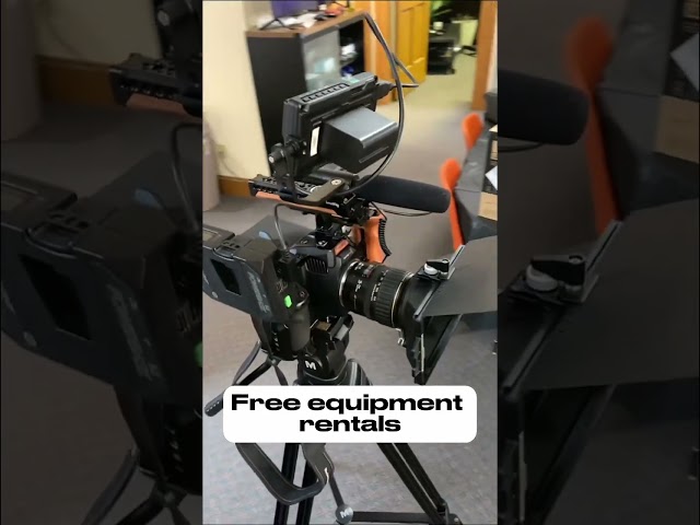 A professional video camera mounted on a sturdy tripod